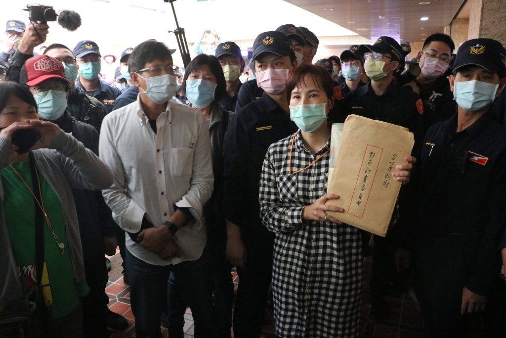 社子島自救會發言人李華萍手持居民陳情書欲進入會場遞交給都委會委員